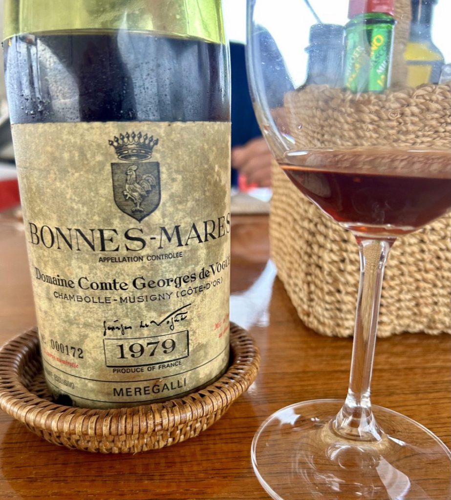 A bottle of 1979 Bonnes-Mares from Domaine Comte Georges de Vogüé beside a glass of red wine