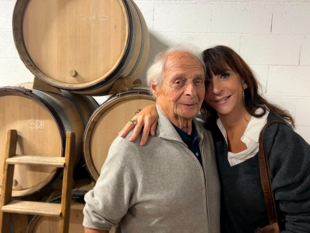 Linda Hamilton-Evans with Patrick Leflaive among oak barrels in a cellar in Puligny-Montrachet